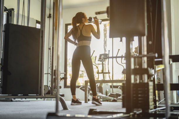 健身、饮食、健身、运动、生活方式和健康理念。女人为了减肥而运动，穿运动服的女人喝乳清蛋白，为了节食而运动。运动的概念。图片下载