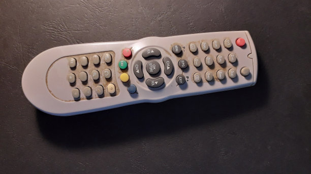 老电视遥控器在桌子上开着图片下载