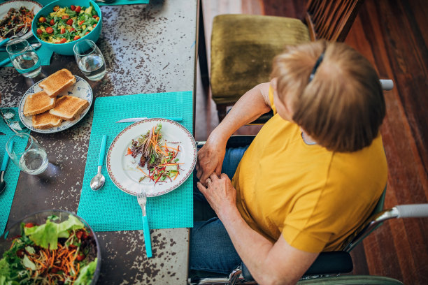 坐在轮椅上独自吃饭的老妇人图片下载