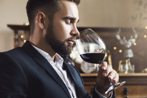 蓄着胡须的帅哥，端着一杯红酒图片下载