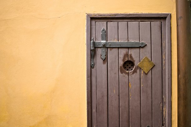 黄色墙壁背景中的中世纪木门(布拉格，捷克共和国，欧洲)图片下载
