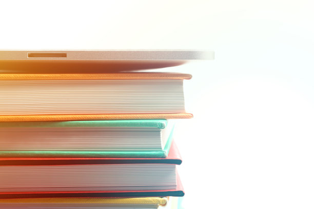 数字平板上的一堆书与白色的背景图片下载