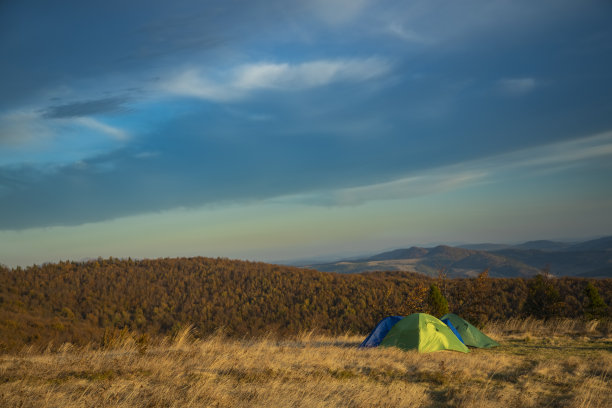 徒步徒步的生活方式旅行摄影帐篷在山区的穆迪风景景观自然环境壁纸查看多云的天空背景，空的复制空间为您的文字图片下载