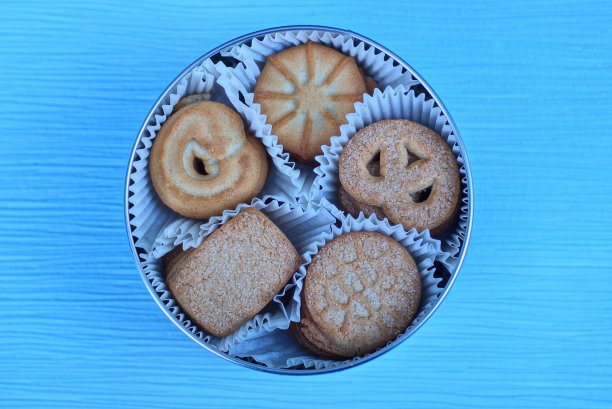 一个棕色的金属盒子，里面装着一套白色纸包的棕色饼干图片下载