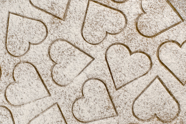 姜饼背景，切成心形，撒上面粉图片下载