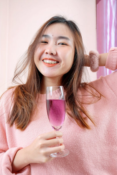 一个漂亮的亚洲女人的肖像拿着一杯美味的果汁。健康的生活方式。图片下载