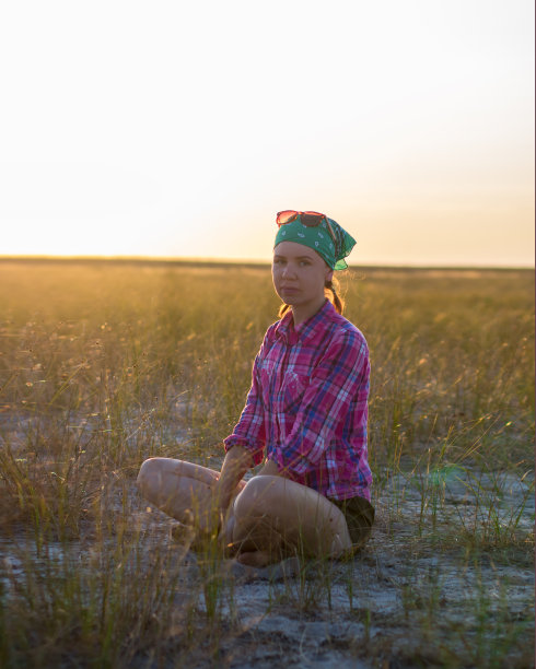 红头发的女孩花时间与愉快在夏日草原日落图片下载