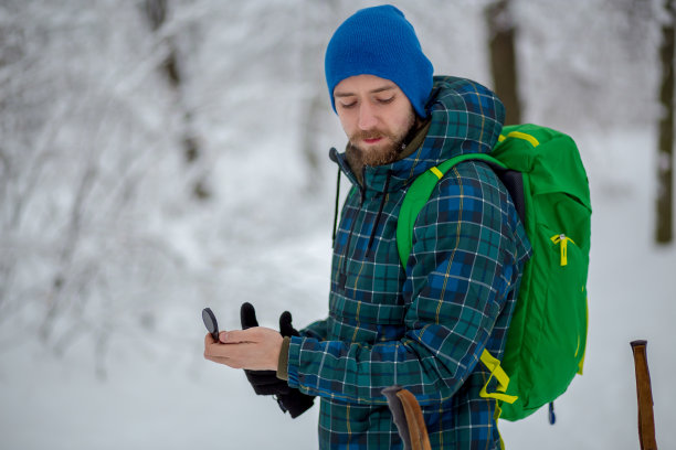 这个人看着雪山背景上的指南针图片下载