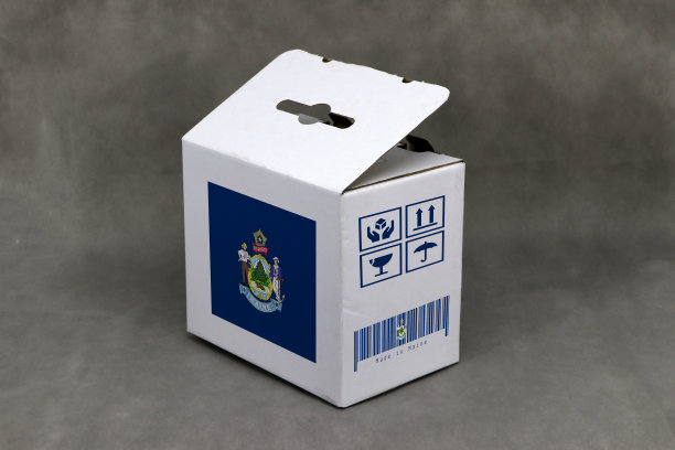 缅因州国旗在白色盒子与脆弱的符号和条码在灰色背景。缅因州出口贸易的概念。图片下载