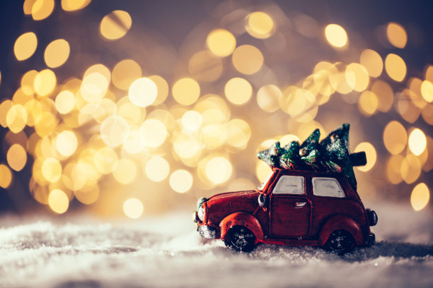 带着圣诞树的玩具车在雪地里行驶。图片下载