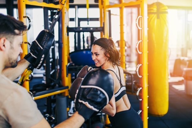 年轻女子在拳击训练出拳袋图片下载