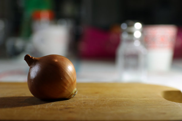 洋葱放在木砧板上。图片下载