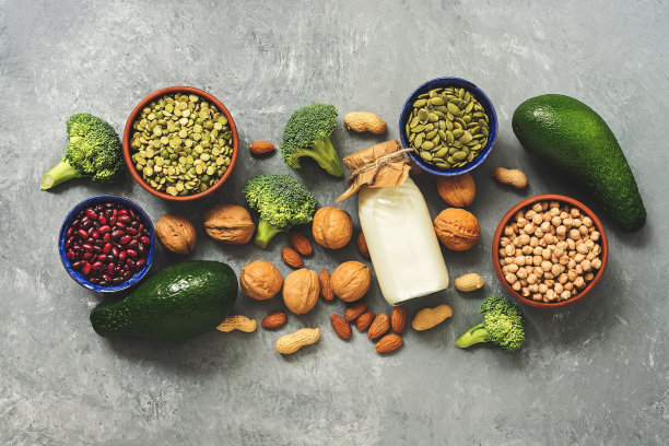 健康饮食:牛奶，豆类，南瓜子，豌豆，坚果，鳄梨和在灰色混凝土背景下的西兰花。素食者的蛋白质来源,横幅。俯视图，平躺，边界。图片下载