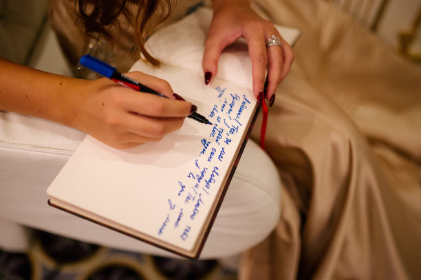 女人用记号笔在相册里写字。在黑线纸上刻上装饰性的字母图片下载