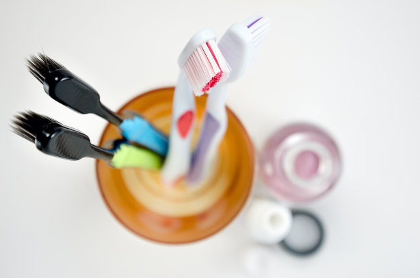 多种颜色的牙刷在一个玻璃上的光背景俯视图，选择性聚焦图片下载