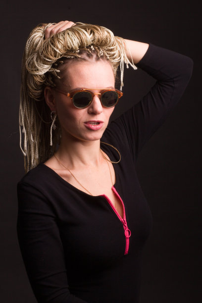 时尚拍女人太阳镜。用齐齐的技术把辫子编成辫子，这是一种富有创意的多彩发型。动感空气舞蹈图片下载