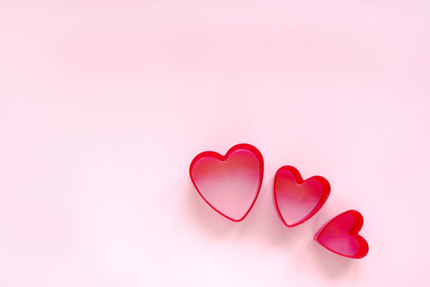创造性的节日爱的概念。粉色背景上的心形饼干切割器。情人节的概念。俯视图，平放。副本的空间。图片下载