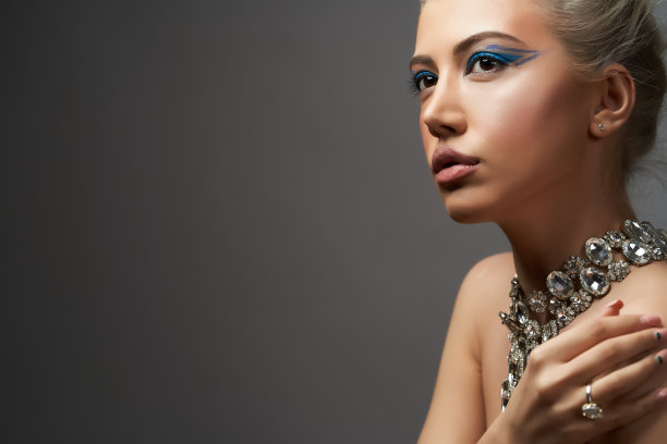 美丽的女人与美丽的化妆在灰色背景与复制空间图片下载