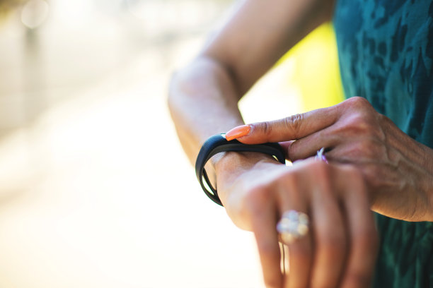成熟的成年女性在户外运动时用智能健身追踪器检查心率图片下载