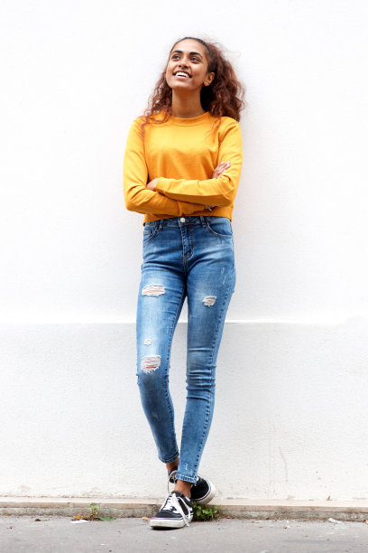 幸福的年轻女子微笑着，双臂交叉的白色墙壁图片下载