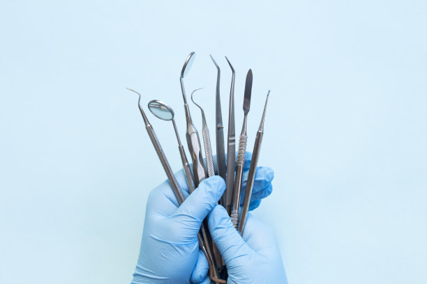 戴手套的手和牙科设备图片下载