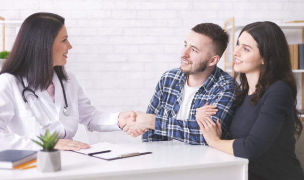 感激的年轻夫妇与家庭治疗师握手图片下载