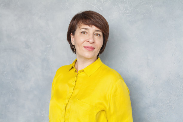 幸福的中年商业妇女在灰色的背景，肖像图片下载