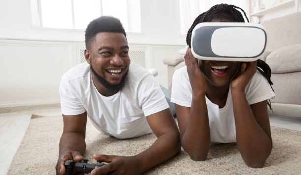 兴奋的非洲夫妇戴着VR眼镜在家玩视频游戏图片下载