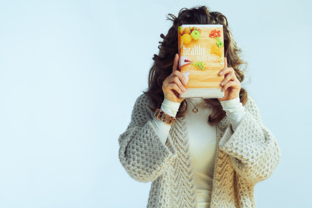 年轻女子拿着健康饮食书在面前图片下载