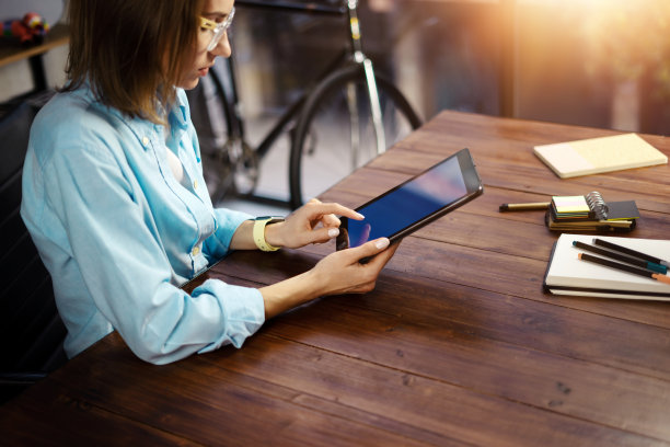 女人用手指着平板电脑屏幕，在社交网络上聊天，在会议网站上聊天，搜索互联网，发送短信，使用短信或网上银行。近距离的照片图片下载