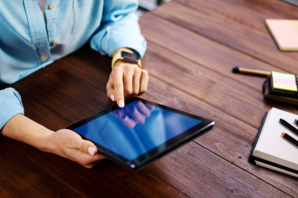 女人用手指着平板电脑屏幕，在社交网络上聊天，在会议网站上聊天，搜索互联网，发送短信，使用短信或网上银行。近距离的照片图片下载
