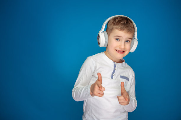 小男孩戴着白色耳机听音乐图片下载