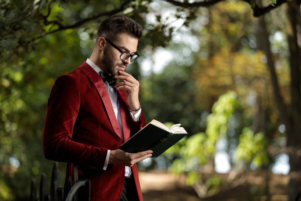 商人一边看书，一边摸着下巴沉思图片下载
