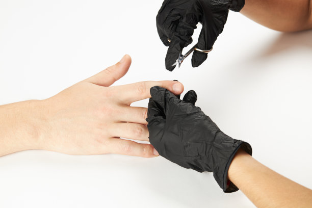 美甲师在工作中使用修指甲剪刀。一个男士修指甲的过程。一个面目全非的白种人在水疗沙龙做美甲服务。男性美容保健图片下载