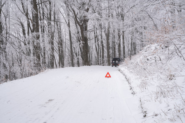 雪山道路上的交通事故与事故三角标志图片下载
