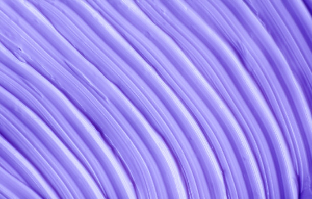 紫色面霜(面膜、裹体、洗发香波或护发素)质地近距离，选择性聚焦。薰衣草抽象背景与画笔笔触。图片下载
