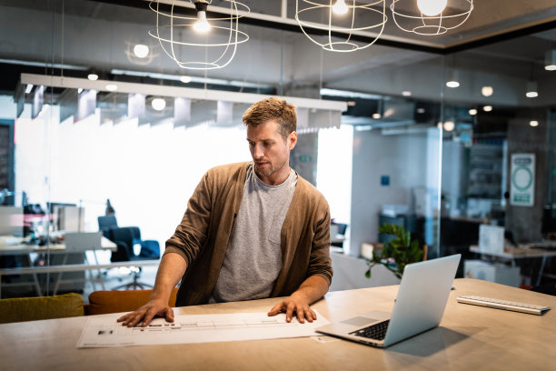 建筑师的肖像是与蓝图在办公室工作图片下载