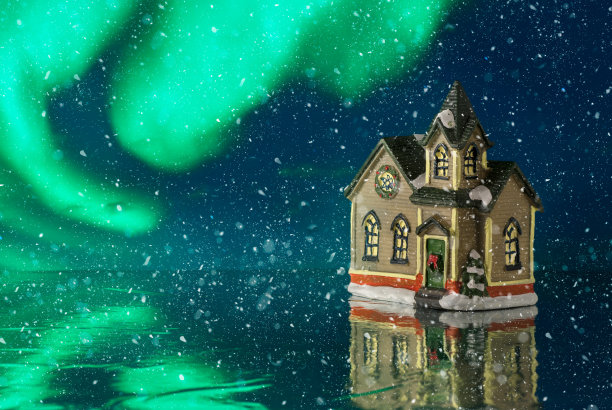 美丽的冬季创作。圣诞节的故事。雪中的小玩具屋。极光的背景。近距离图片下载