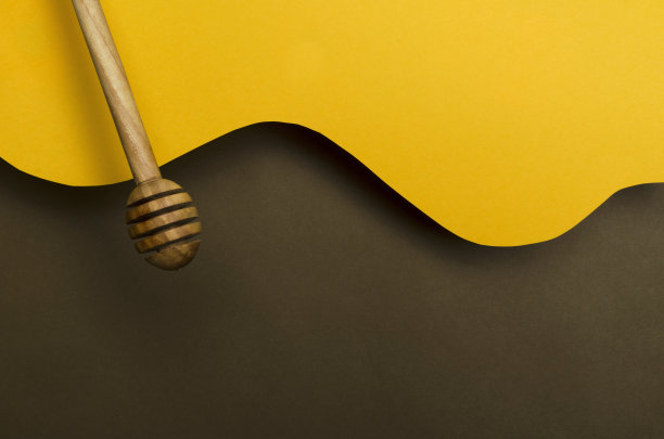 黄色和棕色背景的蜂蜜勺。有机蜂蜜和包装的概念。空的空间图片下载