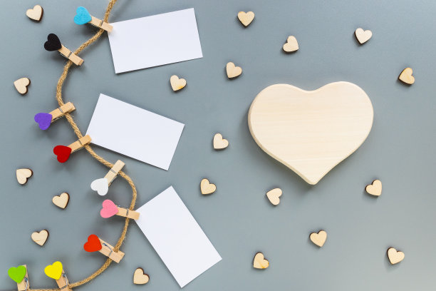 灰色背景上心形的衣夹。大木心与复制空间和许多小心脏图片下载