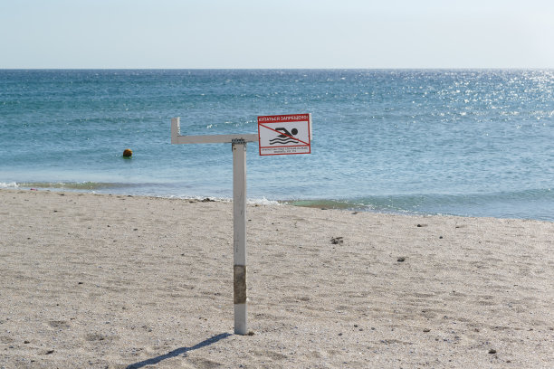 禁止在海边游泳的标志。沙滩和蓝色的水图片下载