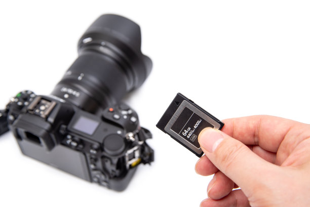 男人的手拿着XQD记忆卡在一个白色的背景。图片下载