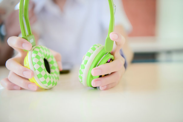 青少年手中彩色耳机的软焦点。快乐的女人用无线耳机听音乐。耳机是一种用于听音频的输出设备图片下载