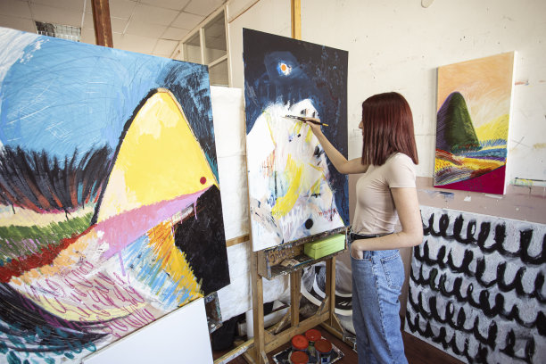 年轻的女艺术家在她的工作室绘画图片下载