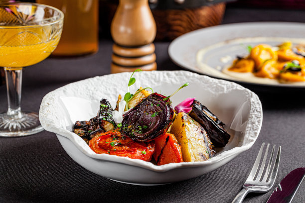 欧洲风格的现代乌克兰菜烤蔬菜，西红柿，红洋葱，茄子，胡萝卜和西葫芦。可食用的花作为装饰。背景图像，复制空间文本图片下载