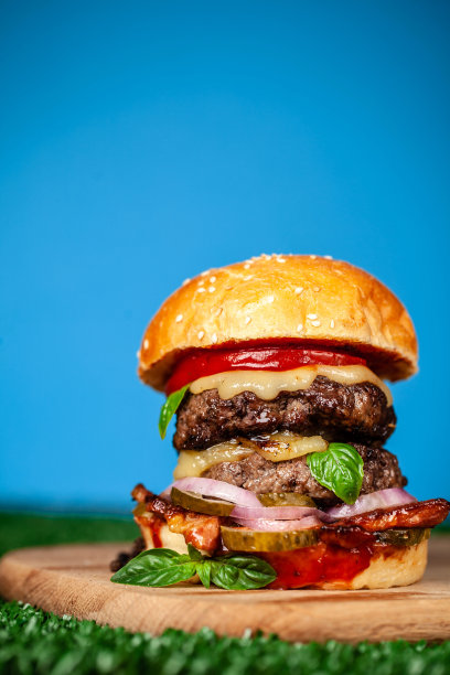 美式家庭汉堡配上两块多汁的牛肉、猪肉、羊肉或小牛肉，在草地上，在天际。的背景图片。街头食品的概念。拷贝空间，俯视图图片下载