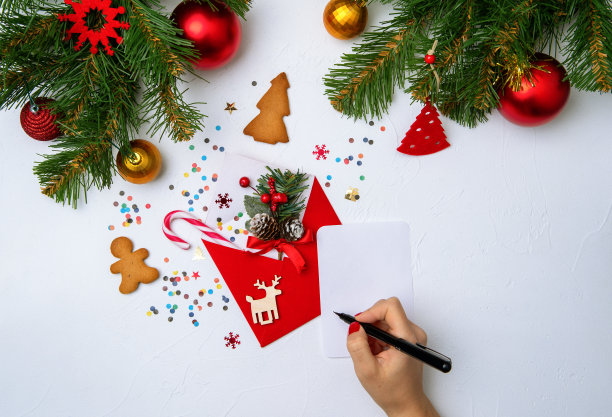 红包照片，饼干，手拿笔，云杉树枝圣诞装饰品图片下载