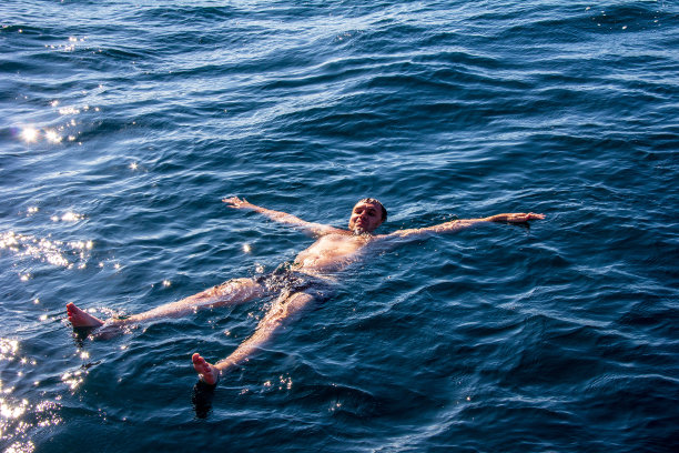 在一个温暖的夏日，快乐的人躺在海水里图片下载