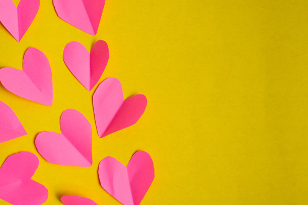 黄色背景上的红纸心。情人节的概念。图片下载