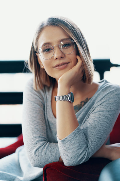 漂亮的女孩坐在舒适的红色椅子上图片下载